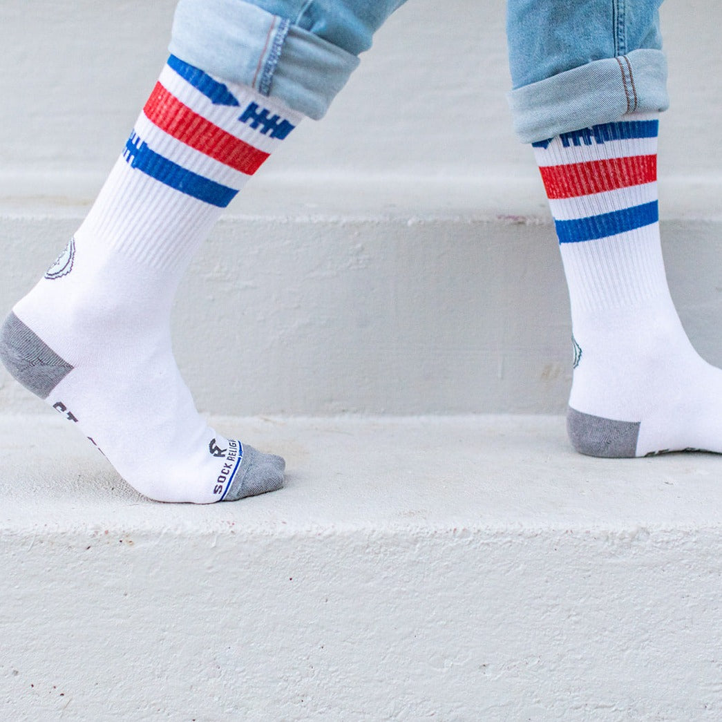a person standing on a step with a pair of white socks with red, white, and blue stripes